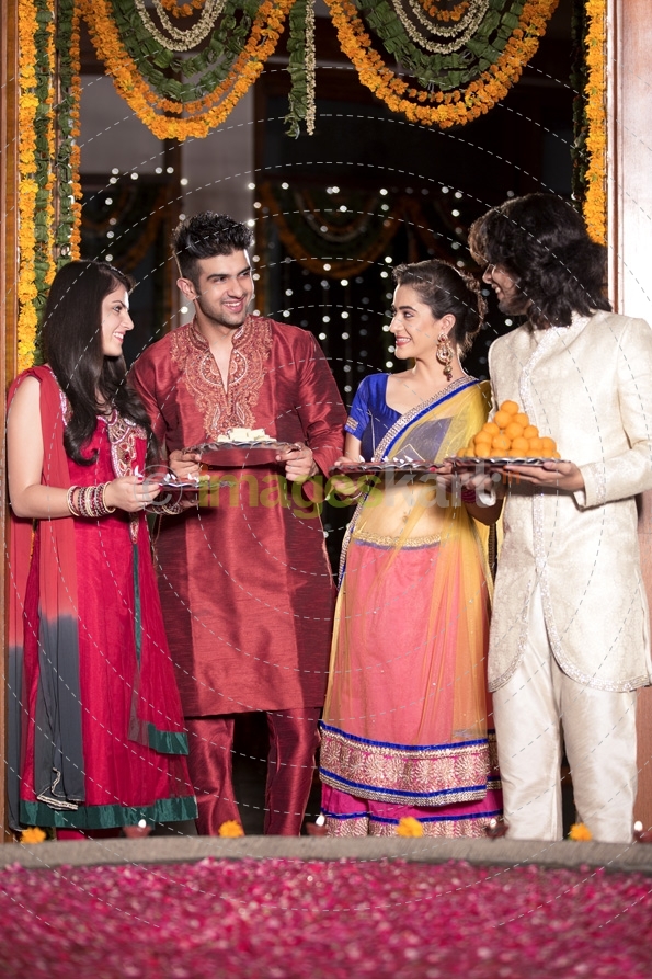 couple in traditional wear standing with thalis