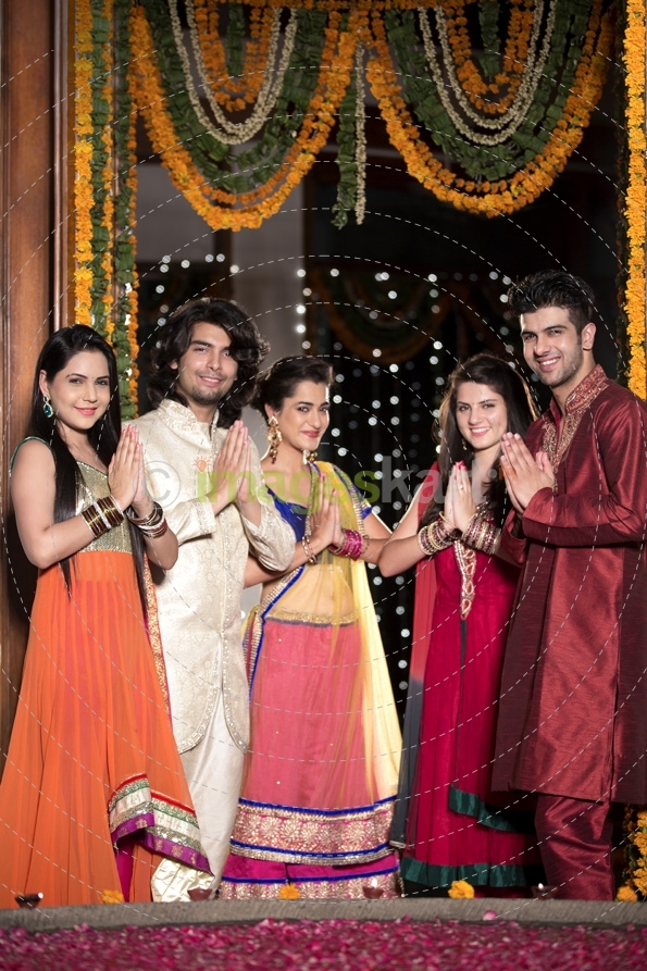 couples with folded hands standing at entrance gate on diwali