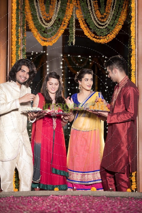 couple in traditional wear standing with thalis