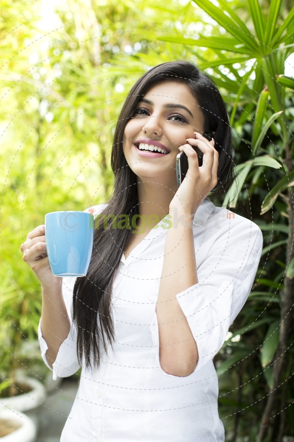 attractive female talking on the phone while having coffee