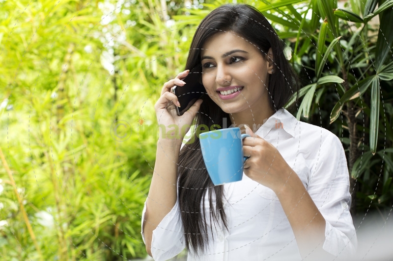 attractive female talking on the phone while having coffee