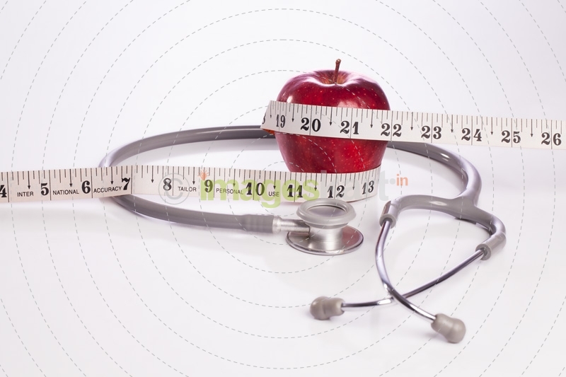 red apple wrapped with a tape and a stethoscope