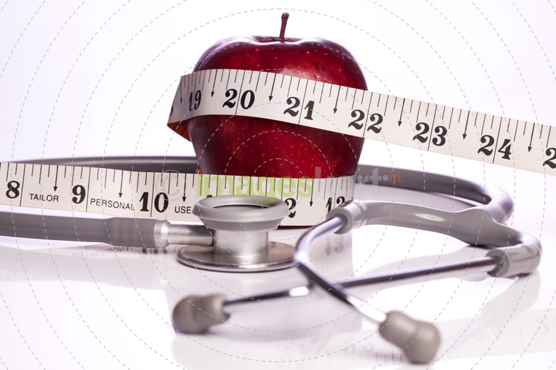 red apple wrapped with a tape and a stethoscope
