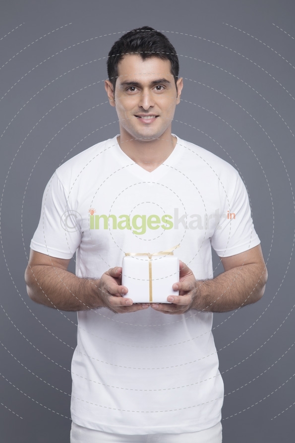 man in white clothing posing with a gift