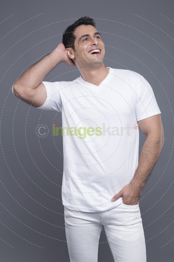 man in white standing with hands in pockets 
