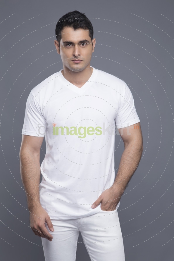 man in white standing with hands in pockets 