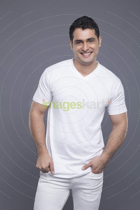 man in white standing with hands in pockets 