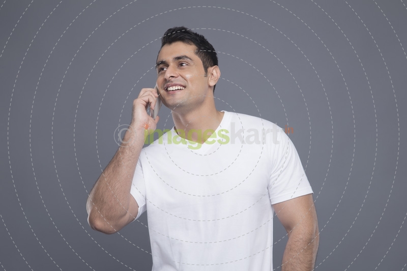 man in white t shirt talking on phone 