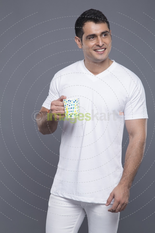 man in white clothes posing with a coffee mug