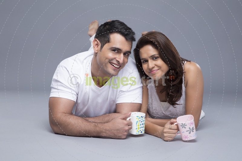 couple lying with front view drinking coffee