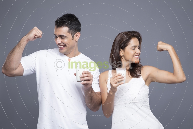 couple drinking milk and showing biceps