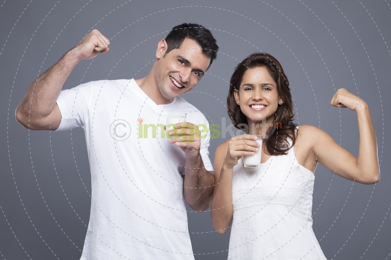 couple drinking milk and showing biceps