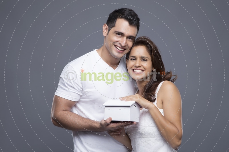 couple posing with toy home