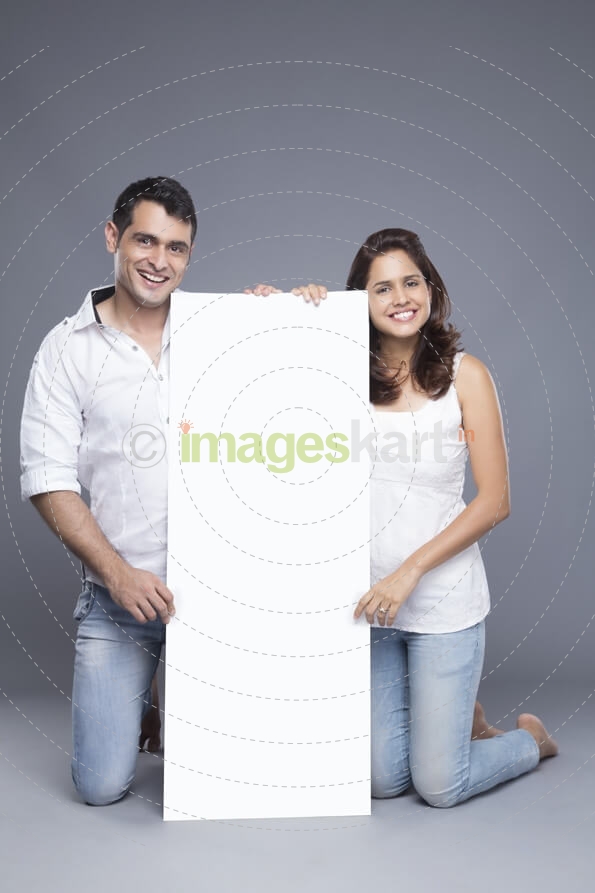 young couple holding a blank poster