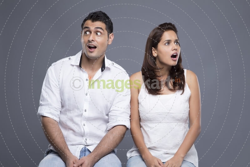 young couple sitting together and looking away