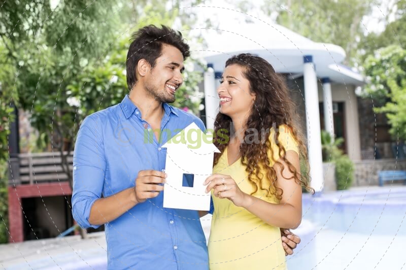 couple showing home cutout outside villa
