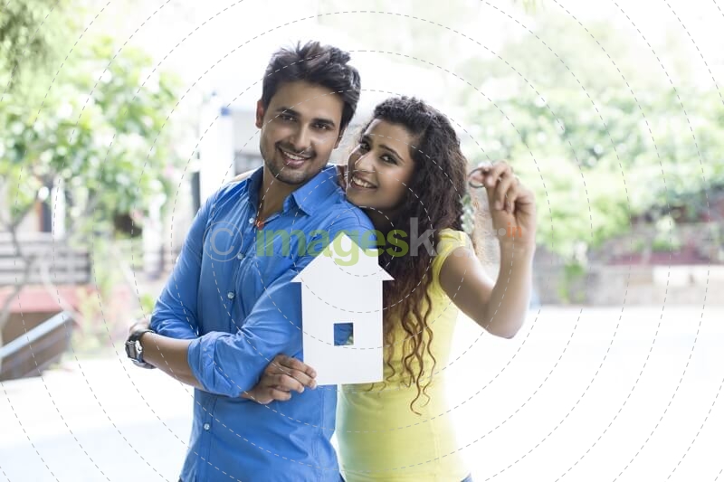 couple showing home cutout outside villa