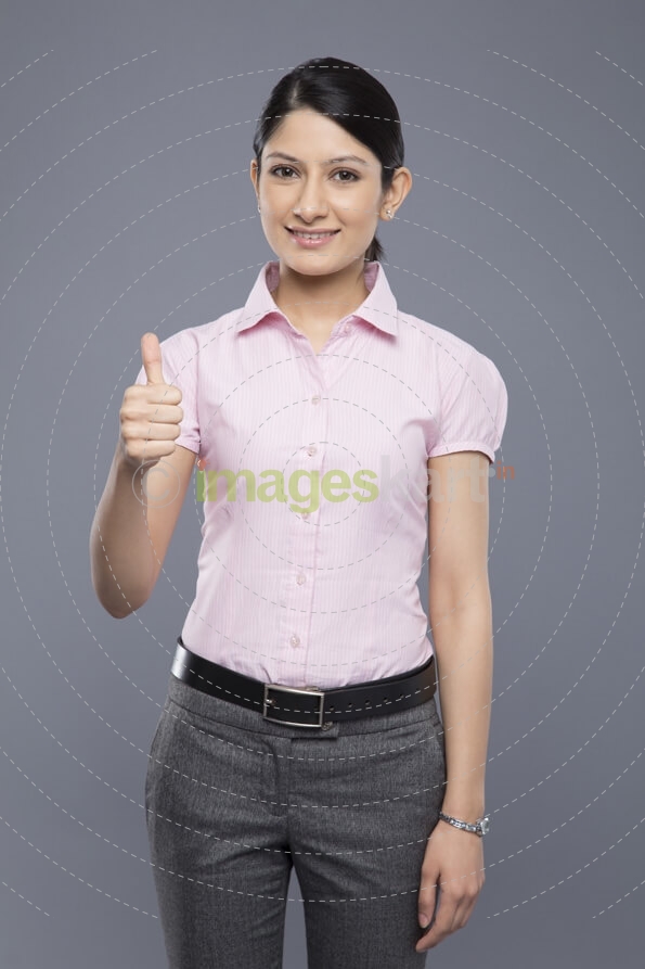 portrait of young business woman showing thumbs up sign