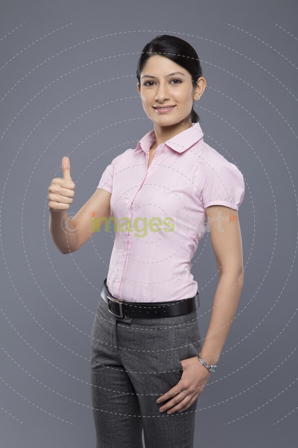 portrait of young business woman showing thumbs up sign