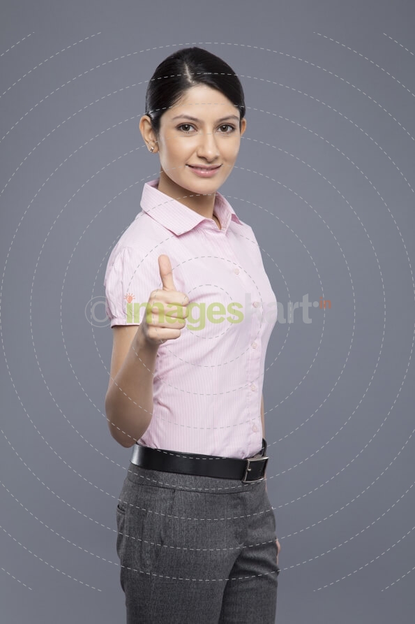 portrait of young business woman showing thumbs up sign
