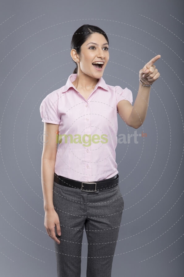 cheerful beautiful business woman pointing and looking at copyspace