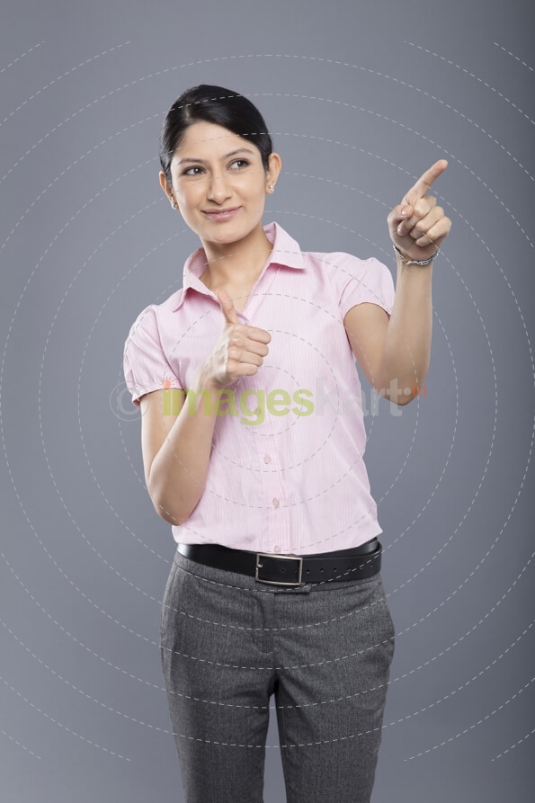 cheerful beautiful business woman pointing and looking at copyspace