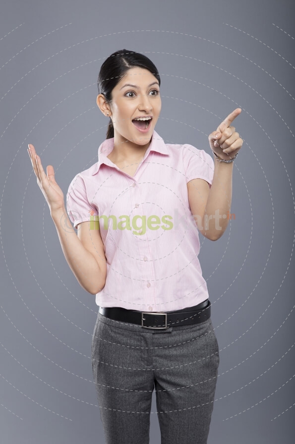 cheerful beautiful business woman pointing and looking at copyspace