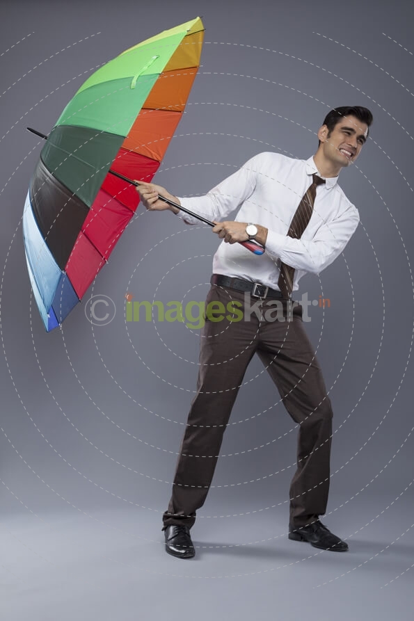man in formal clothes posing with an umbrella 
