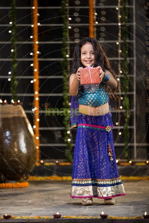 cheerful small girl offering a present on diwali