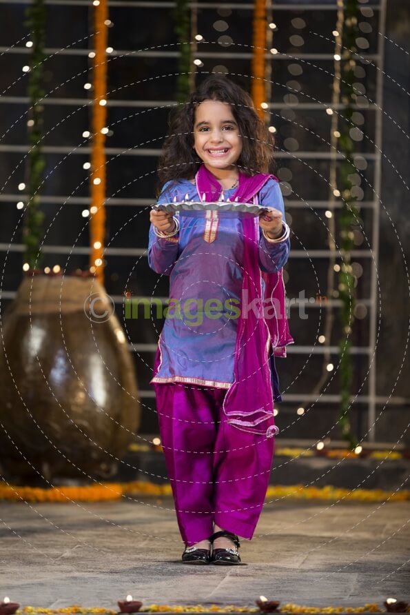 sweet girl holding a pooja thali on diwali