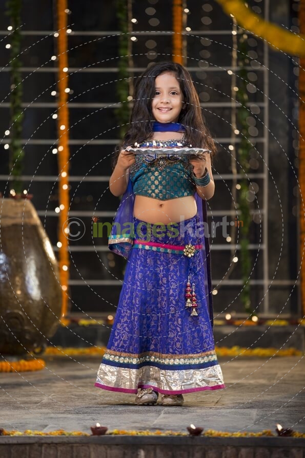 sweet girl holding a pooja thali on diwali