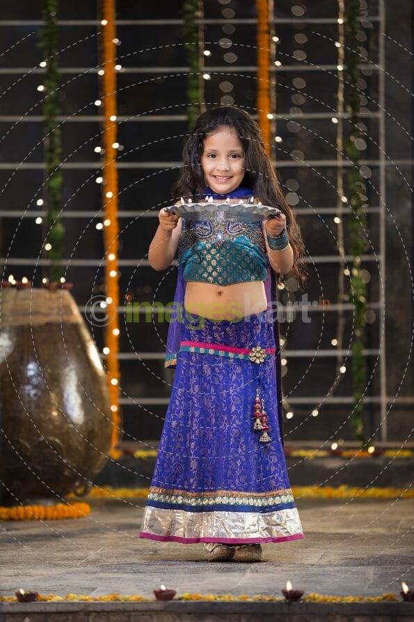 sweet girl holding a pooja thali on diwali