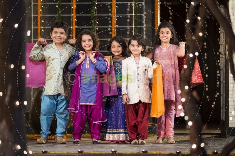 five small kids dressed in traditional outfit holding shopping bags