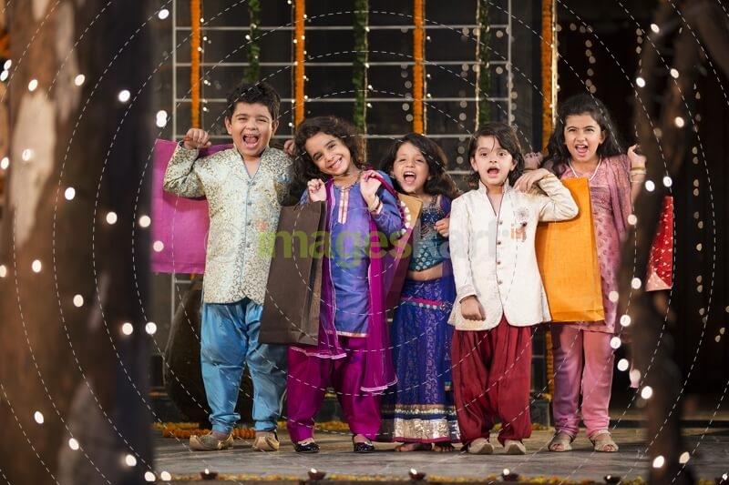 five small kids dressed in traditional outfit holding shopping bags