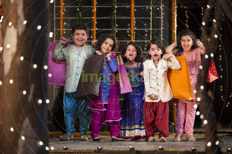 five small kids dressed in traditional outfit holding shopping bags