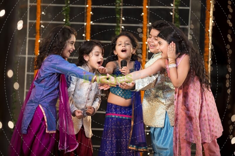 group of kids singing a song on a microphone on diwali