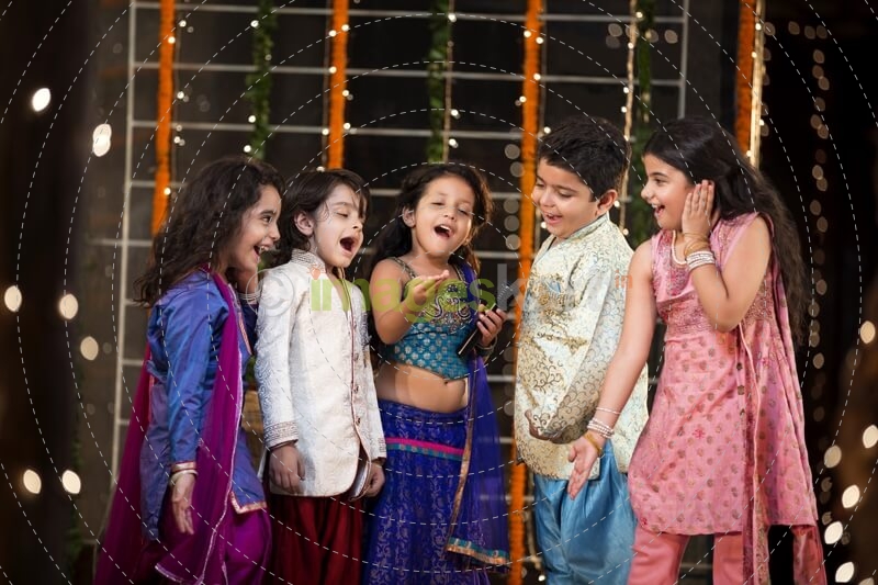 group of kids singing a song on a microphone on diwali