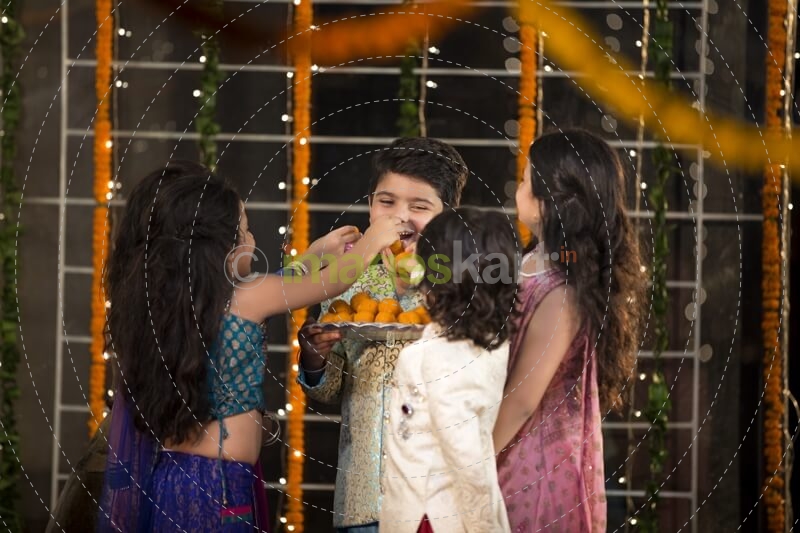 kids offering laddu to their friend