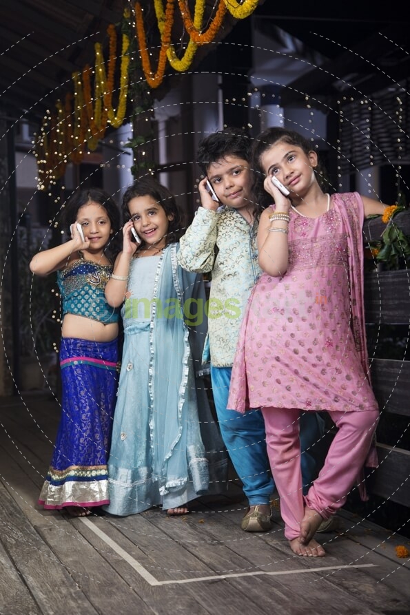 kids in traditional wear talking on phone 
