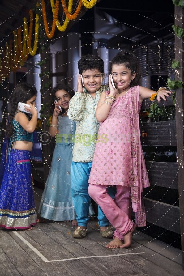 kids in traditional wear talking on phone 