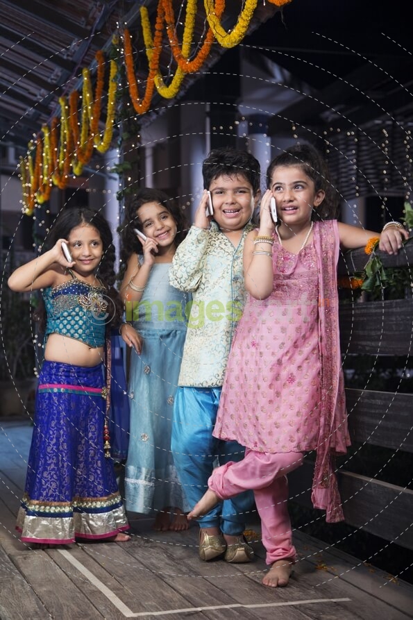 kids in traditional wear talking on phone 