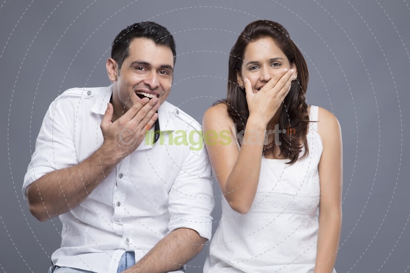 couple with mouth covered by hands 