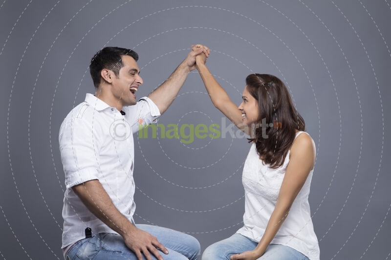 couple sitting and posing by making a heart 