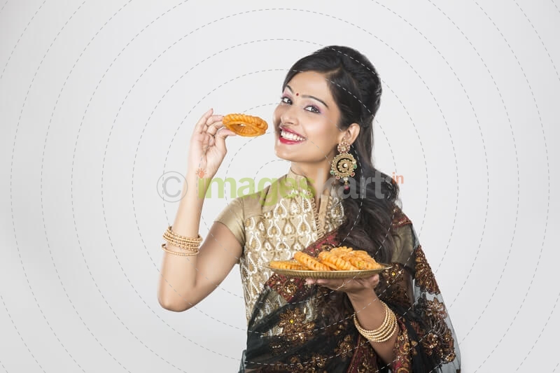 woman in saree with sweets 