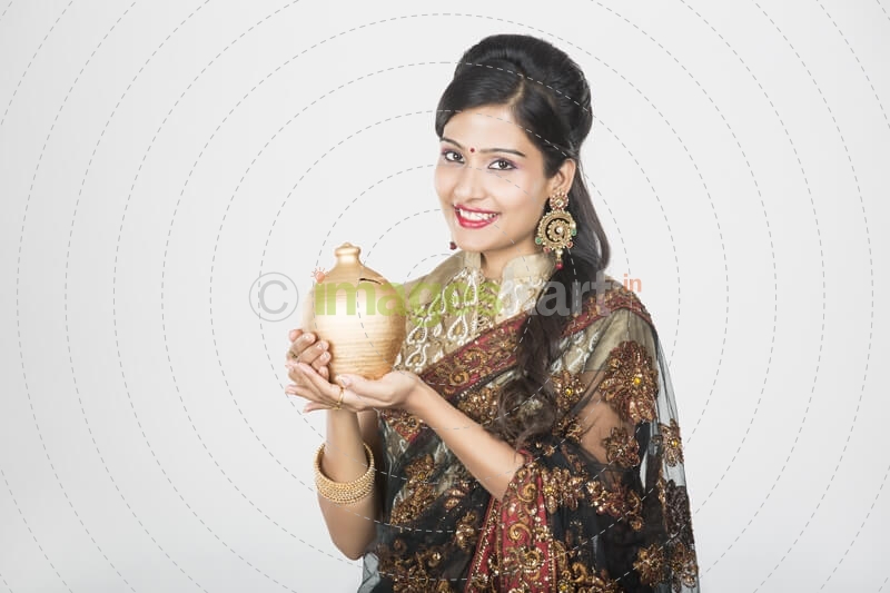 woman in saree with piggy bank 