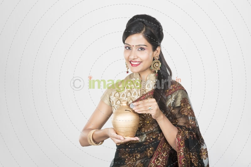 woman in saree with piggy bank 