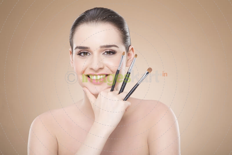 girl posing with make up brush and smiling