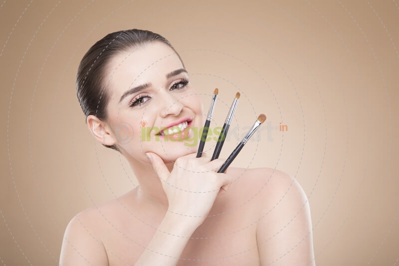 girl posing with make up brush and smiling