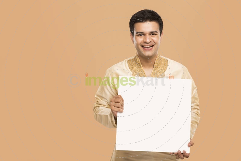 man wearing kurta posing with message board