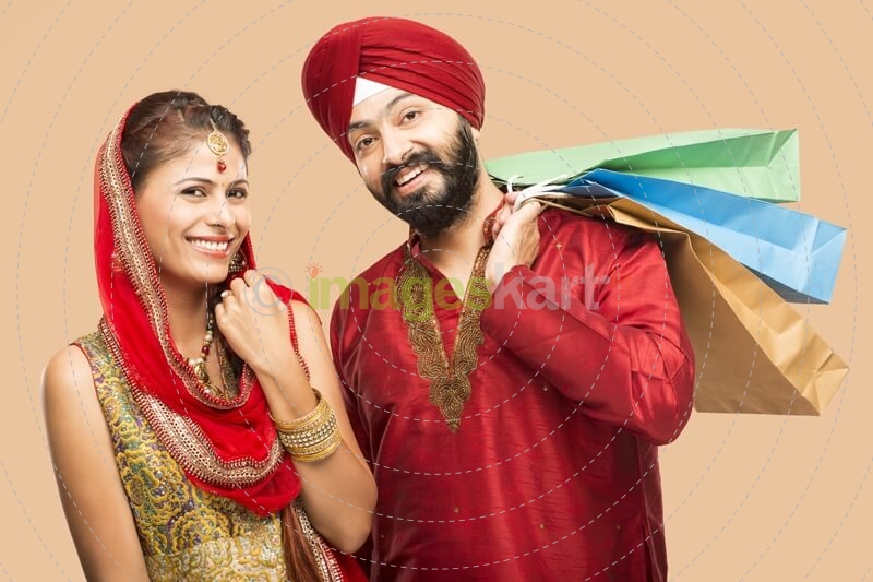 sikh couple posing with gifts and sweets